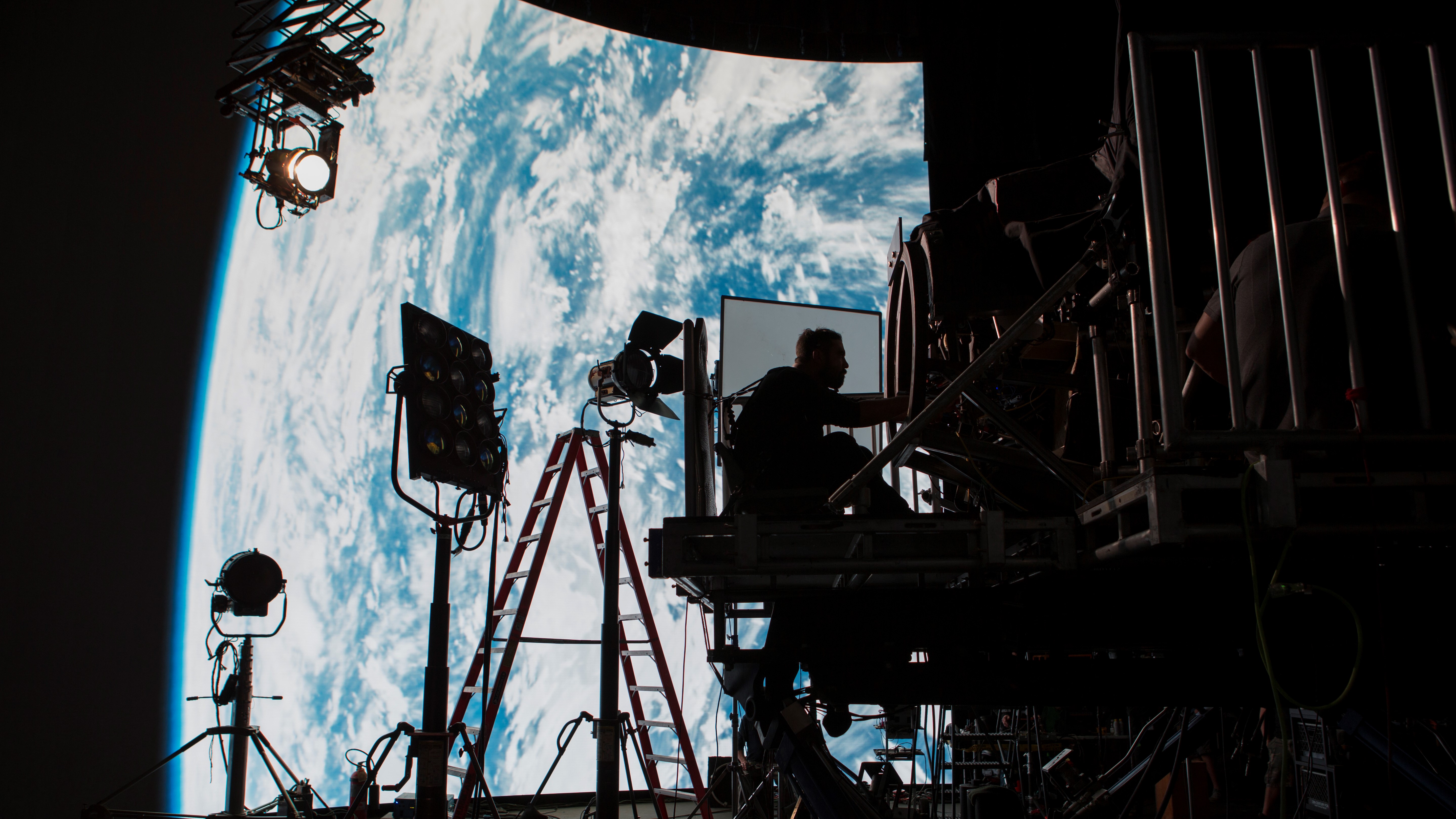 A production set in front of an image of the earth